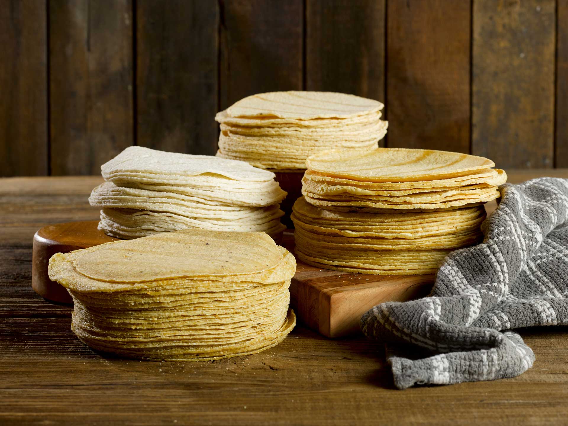 A neatly arranged stack of tortillas resting on a rustic wooden table